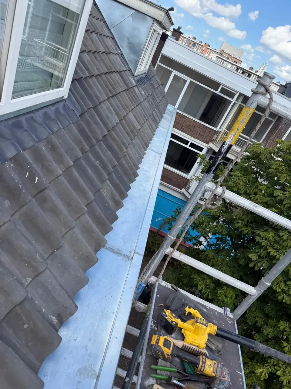 Metal dormer roofs, cheeks and long gutters alongside tiled surfaces.
